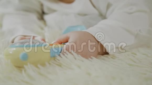 美丽的小女孩躺在白色的床上玩玩具视频的预览图