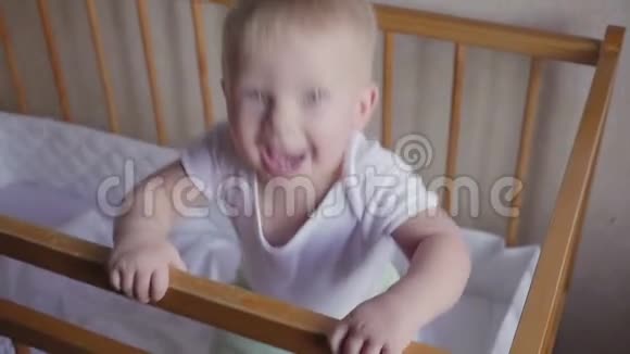 婴儿床上的孩子环顾四周说话跳跃和微笑视频的预览图