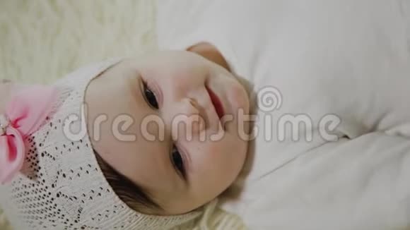美丽的小女孩躺在白色的床上玩玩具视频的预览图