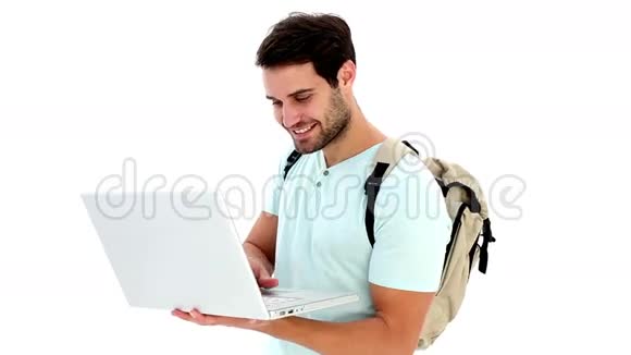 英俊的年轻学生用他的笔记本电脑视频的预览图