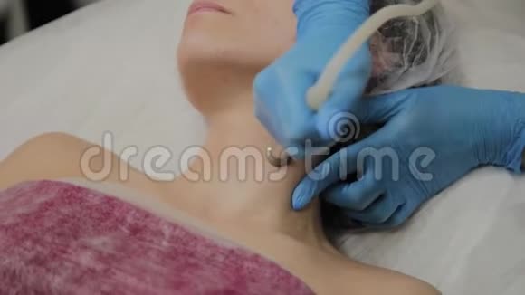 一位专业的美容师让一个女人在美容院用吸尘器清洁脸部宇宙学创新视频的预览图