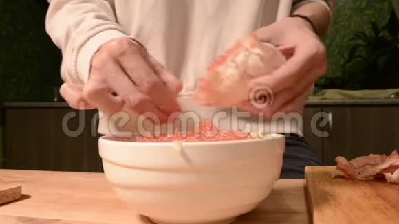 家厨房里的一个女孩用特写的手清洁和切碎葡萄柚做素食沙拉健康的家庭烹饪视频的预览图