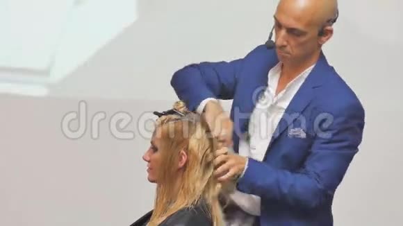 美容师在行动理发师和顾客白发的发型模型舱里的金发在船舱里工作视频的预览图
