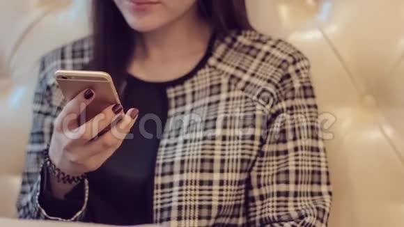 带着电话的漂亮女孩女人在咖啡馆的智能手机上使用应用程序在手机上发短信视频的预览图