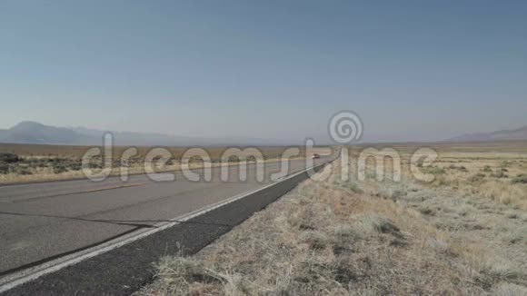 沿着沙漠中的一条路行驶的汽车视频的预览图