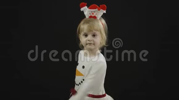 穿雪人服装的快乐美丽的宝贝女孩圣诞节做鬼脸跳舞视频的预览图