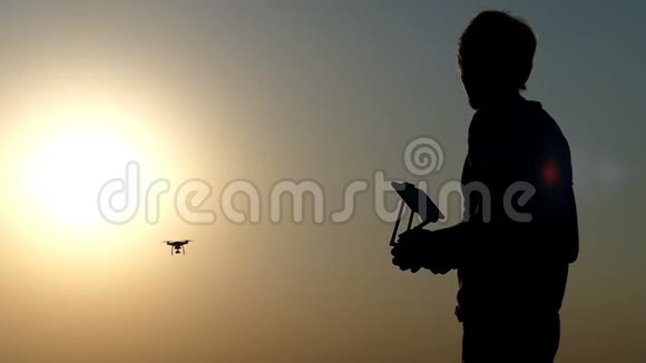 一个人的特写控制面板和日落时的飞行无人机视频的预览图