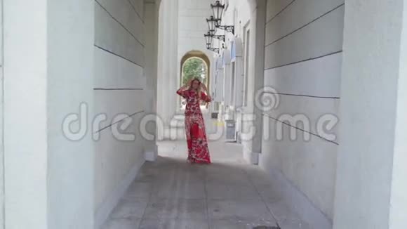 穿着红色裙子在城里散步的女孩视频的预览图