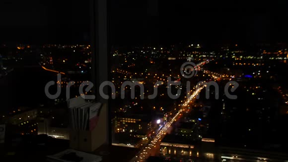 从办公室窗口观看一个夜晚的城市从窗外看美丽的城市视频的预览图