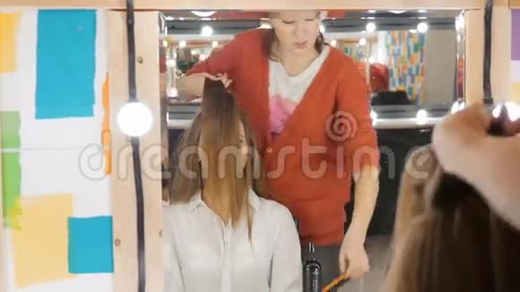 为漂亮女孩做发型的专业理发师视频的预览图