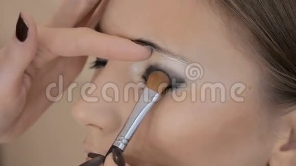 专业化妆师将化妆应用于美丽的模特彩色眼睛视频的预览图