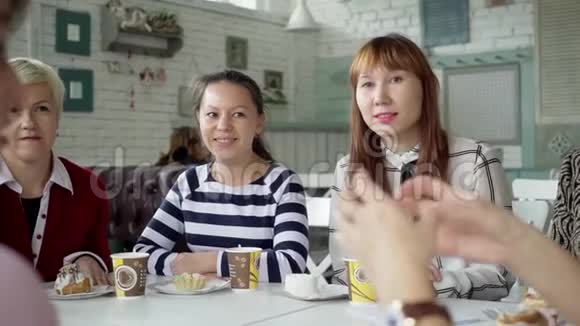 一支女队坐在咖啡馆里喝杯茶同事在午餐期间就不同的话题进行交流女孩们在视频的预览图