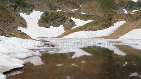 春季高山天然湖泊的鸟瞰图冰雪融化意大利阿尔卑斯山意大利视频的预览图