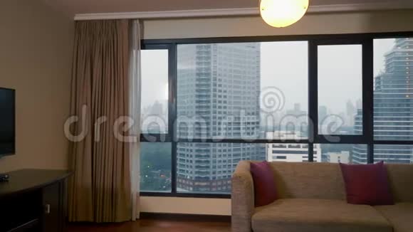 一个在摩天大楼背景上的手提箱在全景窗里的人视频的预览图