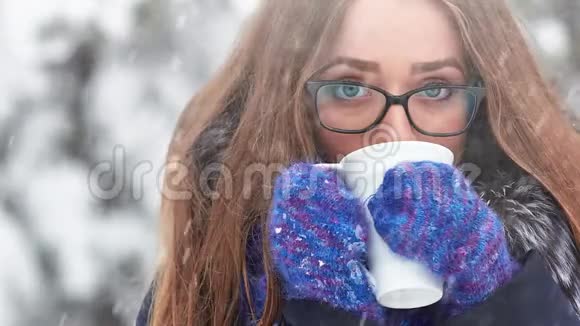 在雪地里拿着杯子的女孩视频的预览图
