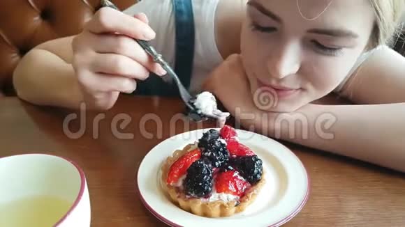 年轻的女人在吃黑莓蛋糕视频的预览图