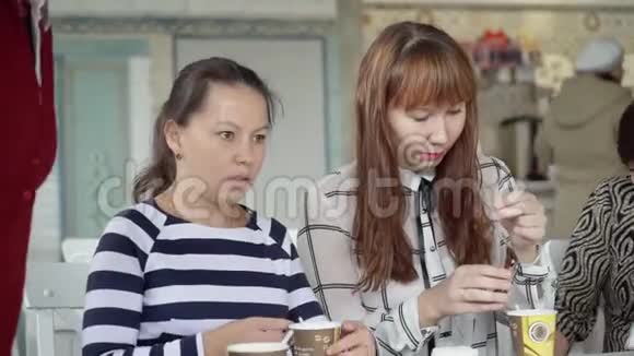 一支女队坐在咖啡馆里喝杯茶同事在午餐期间就不同的话题进行交流女孩们在视频的预览图