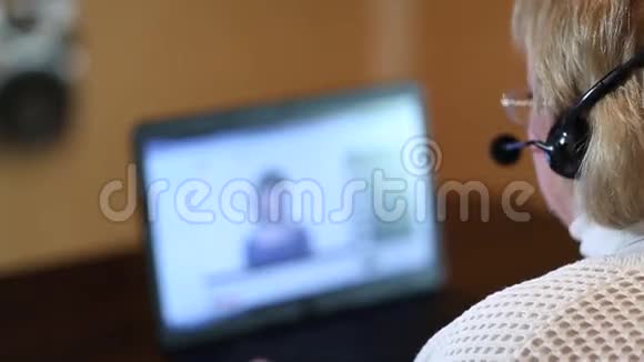 戴着耳机的女人通过电脑与顾客交谈视频的预览图