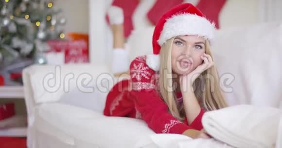 客厅里戴着圣诞帽的漂亮女孩视频的预览图