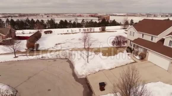 在雪覆盖的郊区社区的家庭空中视频视频的预览图