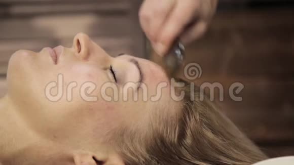 按摩师对女性面部进行穴位按压刮板水痛推拿视频的预览图