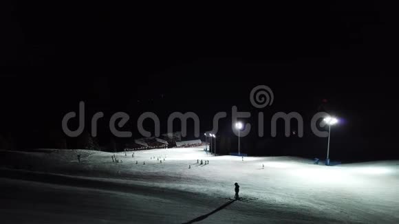 滑雪者在斜坡上的无人机空中视野在蒙特波拉滑雪胜地夜间滑雪视频的预览图