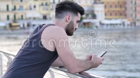 在海边的人用手机输入信息视频的预览图