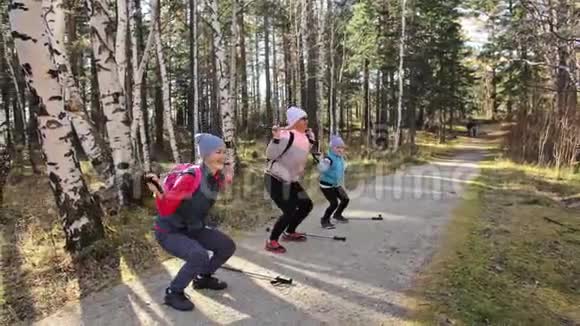 女人在大自然中行走女孩和孩子使用跋涉棒和北欧杆背包家庭旅行视频的预览图