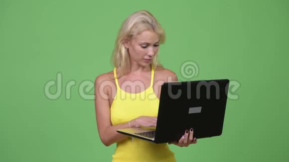 年轻快乐的金发美女在用笔记本电脑思考视频的预览图