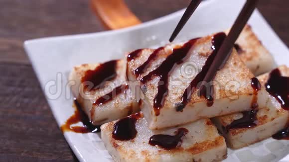 将黑酱油倒入即食美味的萝卜蛋糕上餐厅里的中国传统土菜萝卜蛋糕特写视频的预览图