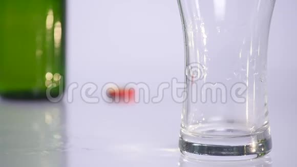 一瓶啤酒倒入白色背景的杯子里视频的预览图