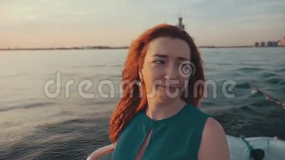 在摩托艇上穿裙子的红头发女孩美丽的夏日夜晚幸福视频的预览图