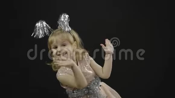 快乐美丽的小女婴穿着光滑的裙子圣诞节做鬼脸跳舞视频的预览图