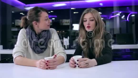 两个漂亮的女孩在咖啡馆里聊天视频的预览图
