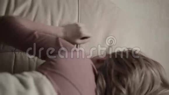 沮丧的女人在床上在沙发上哭泣的女孩视频的预览图