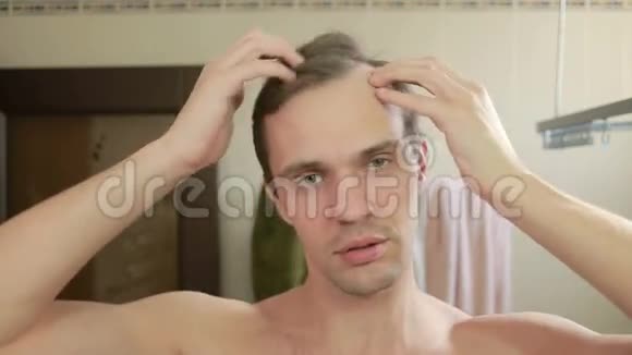 年轻有魅力的男人在浴室里检查一条后退的发际线巴尔德斯视频的预览图