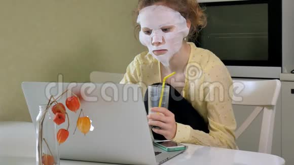 年轻女子带着清洁面罩在家里的笔记本电脑后面工作视频的预览图