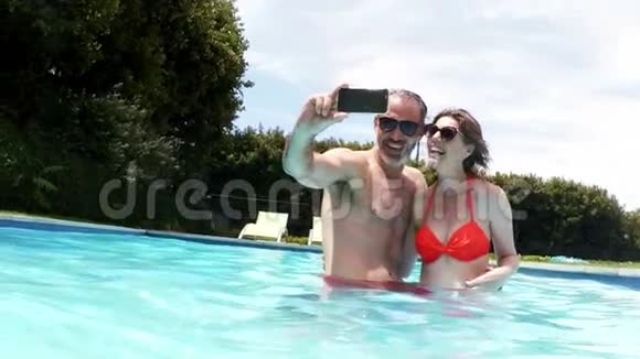 快乐情侣在泳池里用手机自拍视频的预览图