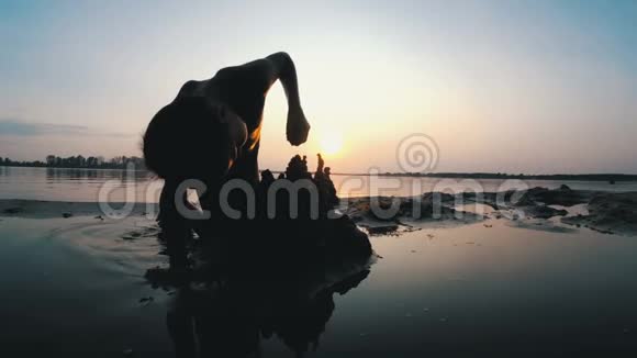 海滩儿童剪影在日落时建造沙堡视频的预览图