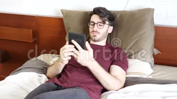 在床上阅读电子书的年轻人视频的预览图