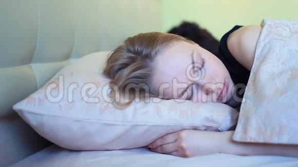 清晨睡得正香的年轻女人在床上和男朋友说话视频的预览图