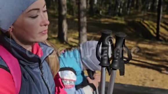 女人在大自然中行走女孩和孩子使用跋涉棒和北欧杆背包家庭旅行视频的预览图