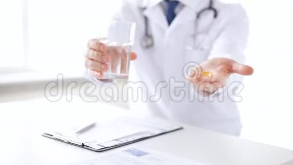 男医生手里拿着药丸和一杯水视频的预览图