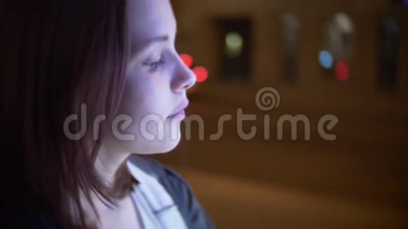 一个可爱的微笑少女在夜城街的肖像4K慢车视频的预览图