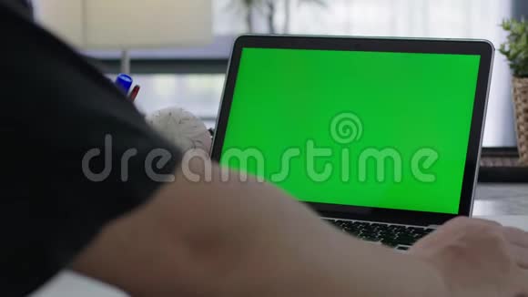 在家工作的女人拿着笔记本电脑绿屏视频的预览图