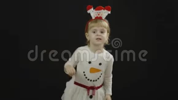 穿雪人服装的快乐美丽的小宝贝女孩做鬼脸跳舞视频的预览图
