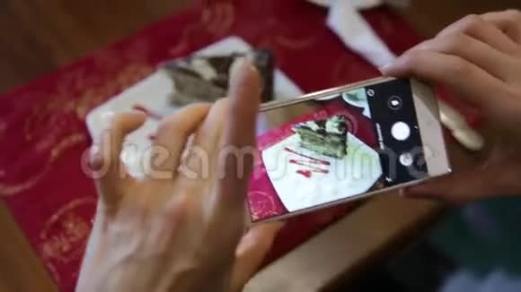 时尚女性在一家餐馆用手机相机为社交网络制作食物照片视频的预览图