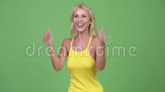 年轻快乐的金发美女一边竖起大拇指一边兴奋视频的预览图