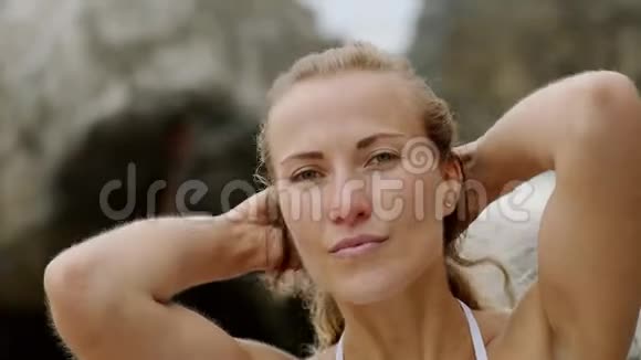 性感的女孩在海滩上的暑假为相机快乐的女孩摆姿势视频的预览图