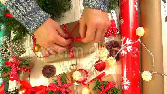 女人正在桌上包装圣诞礼物准备新年和圣诞节假期的概念视频的预览图